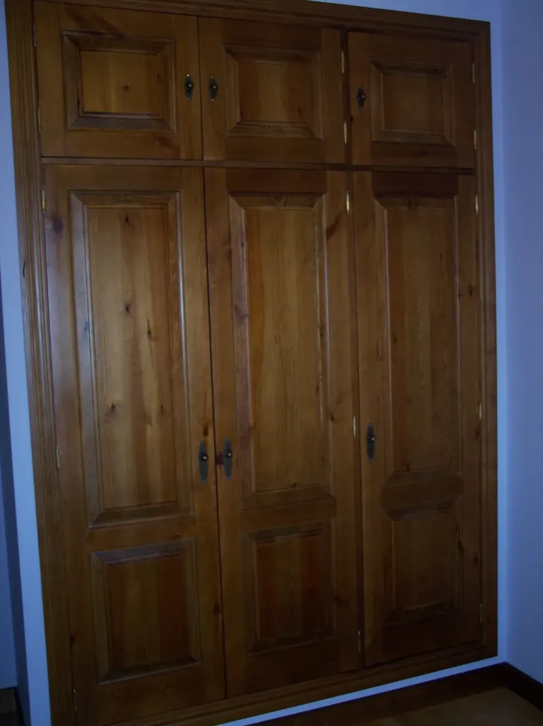 Armario con puertas abatibles de cuarterones en pino tintado
